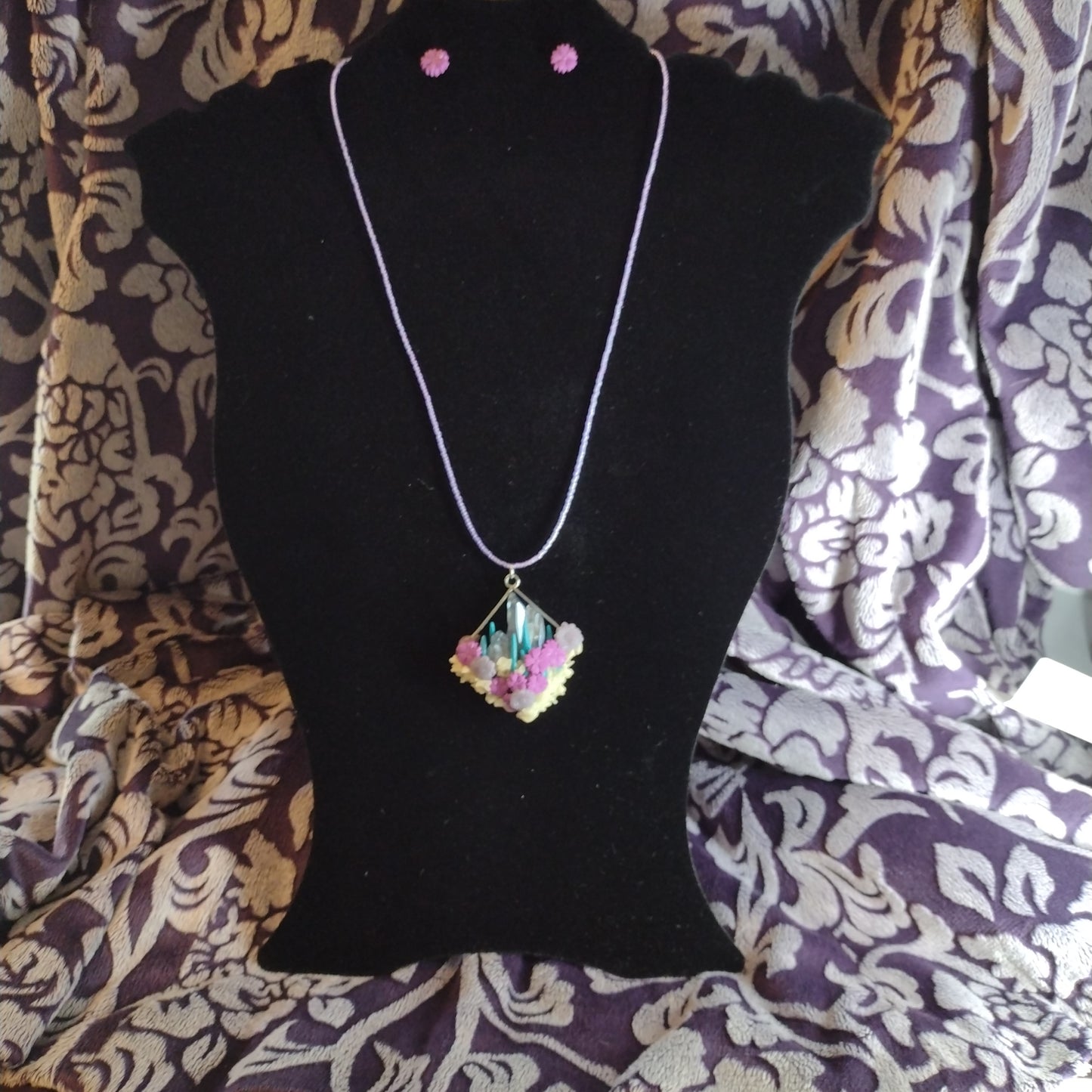 Crystals and glow-in-the-dark pendant on purple seed bead necklace. Matching stud earrings